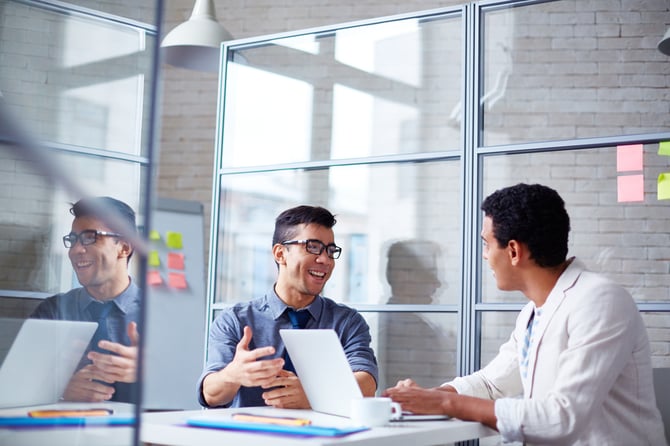 two male coworkers having a discussion in an office